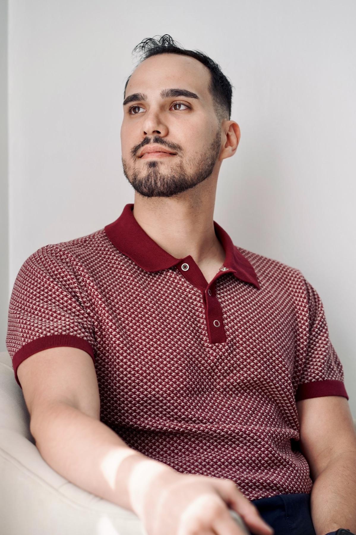 Portrait of Carlos in a red patterned polo, looking off camera