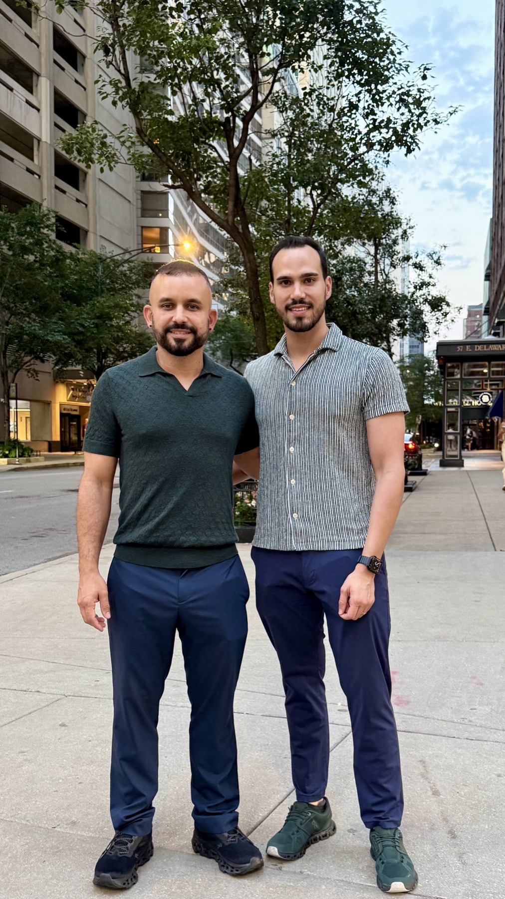 Leo and Carlos standing together on a tree-lined street